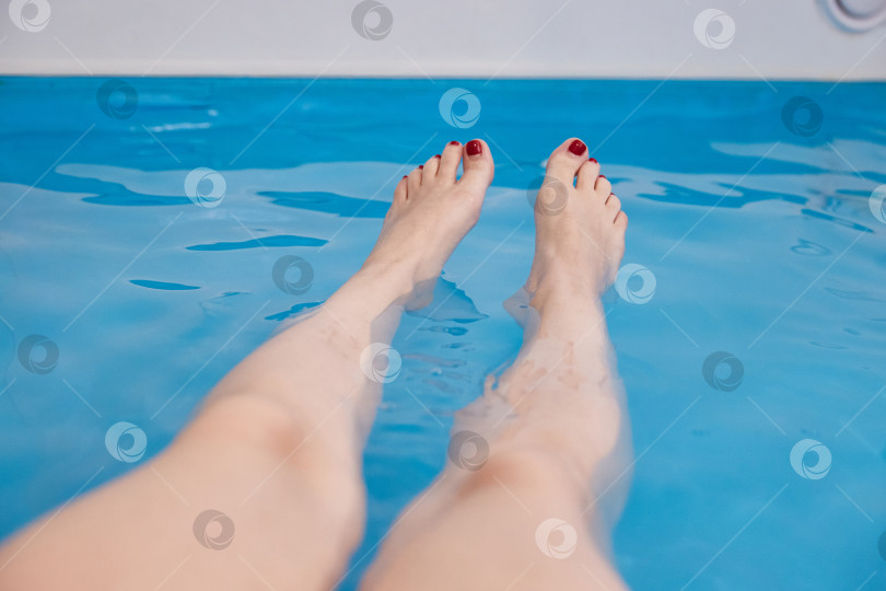 Скачать Женские ножки в бассейне с морской водой. Водные спа-процедуры в санатории. фотосток Ozero