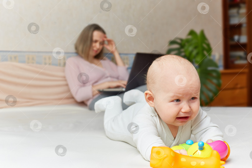 Скачать Ребенок плачет, пока мать работает или играет за компьютером. Концепция работы на дому. фотосток Ozero