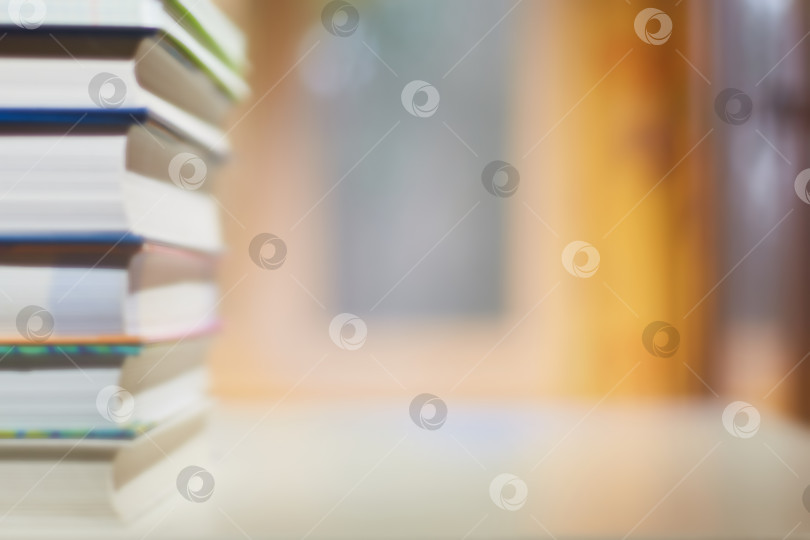 Скачать Образование и профессиональная подготовка. Стопка книг на письменном столе, окно и книжный шкаф расфокусированы. фотосток Ozero