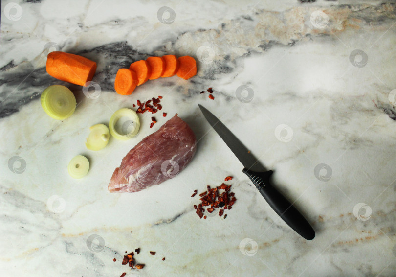 Скачать сырое мясо, овощи, лук, морковь, приправы, сверчки для нарезки ножом. Готовим ужин, режем мясо фотосток Ozero