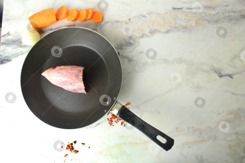Скачать Стейк из сырой свинины на сковороде крупным планом. Приготовление мяса фотосток Ozero