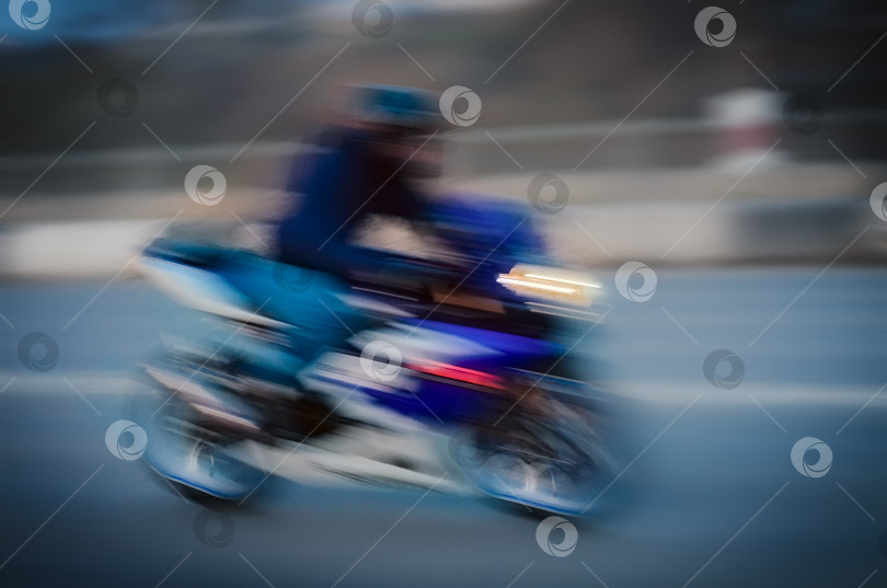 Скачать Размытый фон с быстро бегущим мотоциклистом фотосток Ozero