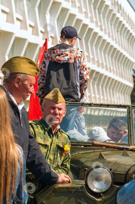 Скачать УЛЬЯНОВСК, РОССИЯ - 9 мая 2016 года: Мужчины в форме Советской Армии времен Второй мировой войны со старым автомобилем. фотосток Ozero
