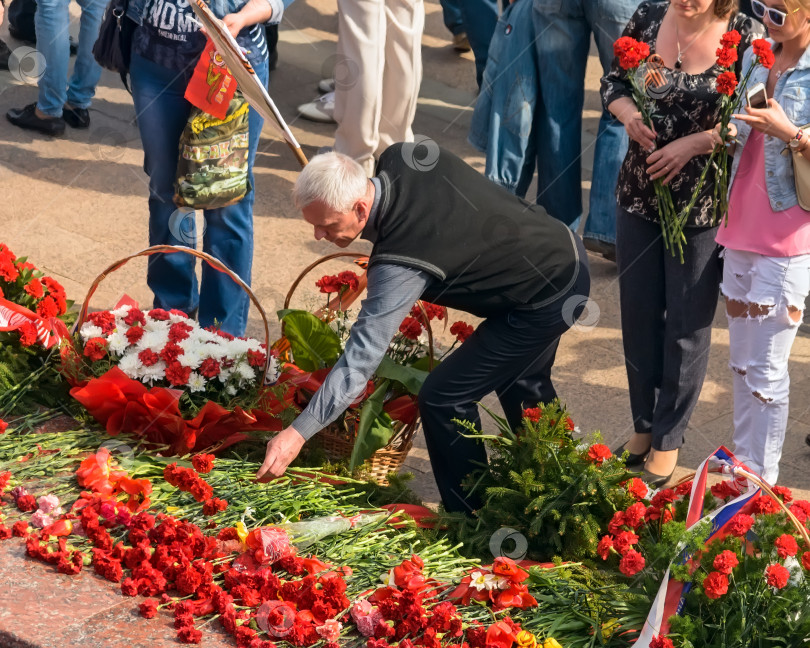 Скачать УЛЬЯНОВСК, РОССИЯ - 9 мая 2016 года: Люди с цветами у Вечного огня. фотосток Ozero
