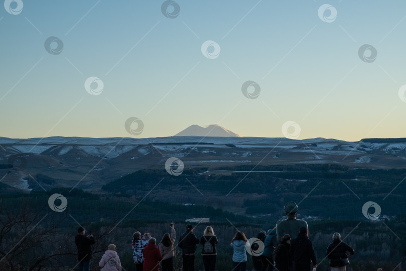 Скачать Люди и памятник Лермонтову смотрят на Эльбрус на закате фотосток Ozero