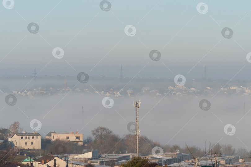 Скачать Густой туман стелется по крышам в пригородном пейзаже. фотосток Ozero