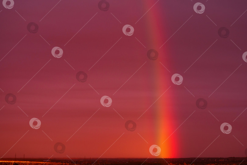 Скачать Ярко-красное закатное небо с поразительной радужной колонной. фотосток Ozero