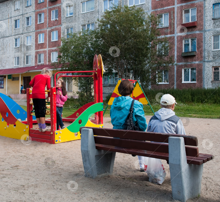 Скачать Мать и дети играют на детской площадке во дворе фотосток Ozero