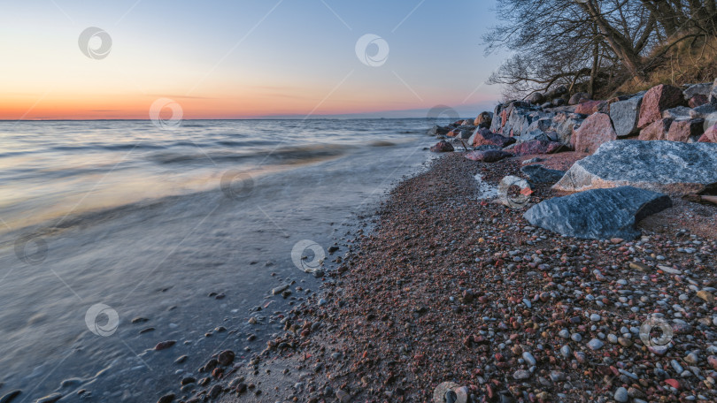 Скачать Оранжевый закат на фоне скалистого морского берега фотосток Ozero