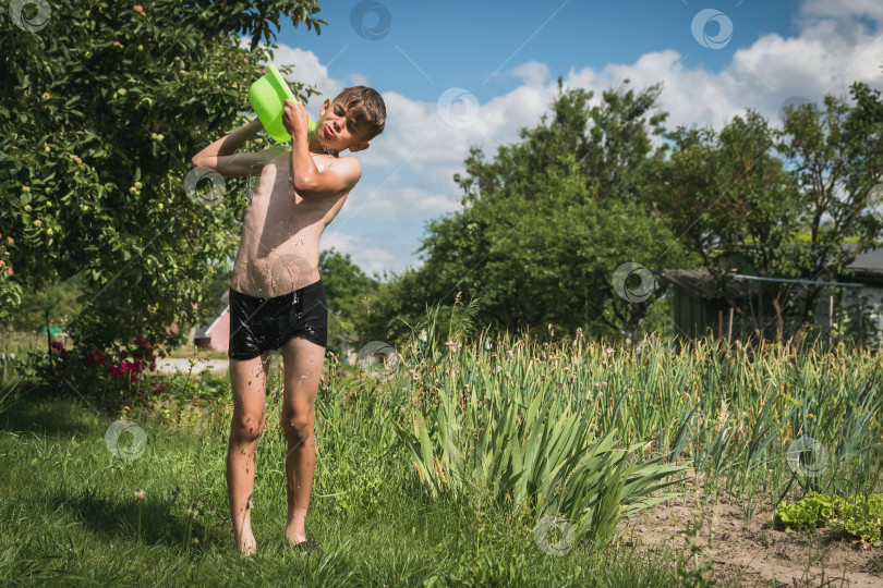 Скачать Маленького мальчика обливают водой во дворе загородного дома фотосток Ozero