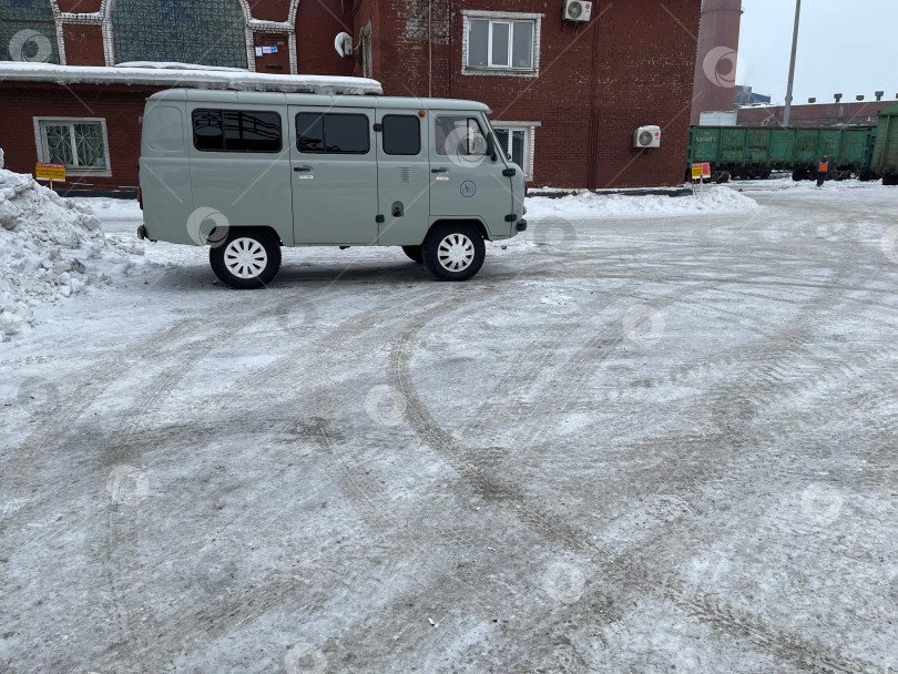 Скачать виды производственной площадки на промышленном предприятии: легковой автомобиль, ожидающий людей возле здания цеха фотосток Ozero