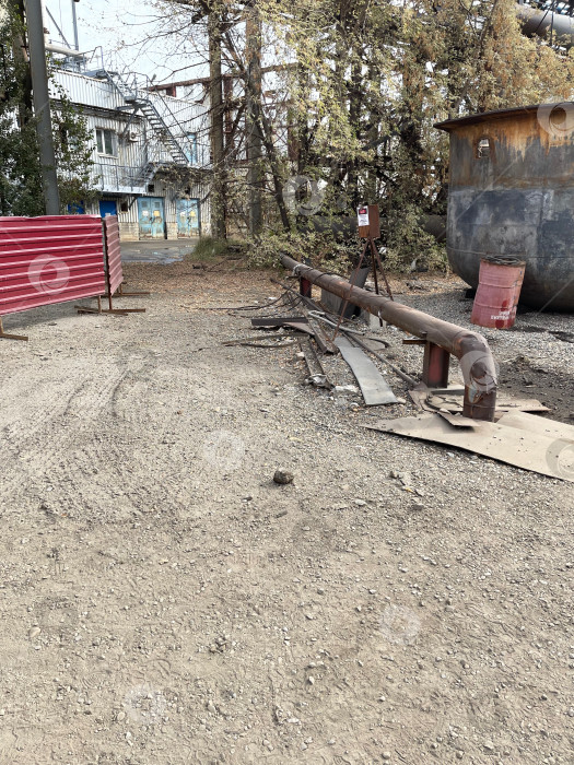 Скачать виды производственной площадки - водопроводные трубы, торчащие из земли и песка на промышленном предприятии фотосток Ozero