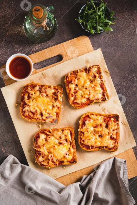 Скачать Домашняя хлебная пицца с беконом и сыром на доске, установленной на столешнице, в вертикальном положении фотосток Ozero