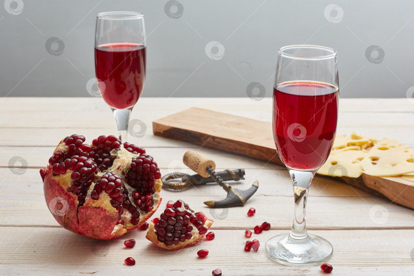Скачать Гранатовое вино на белом деревянном столе. Сыр, штопор фотосток Ozero