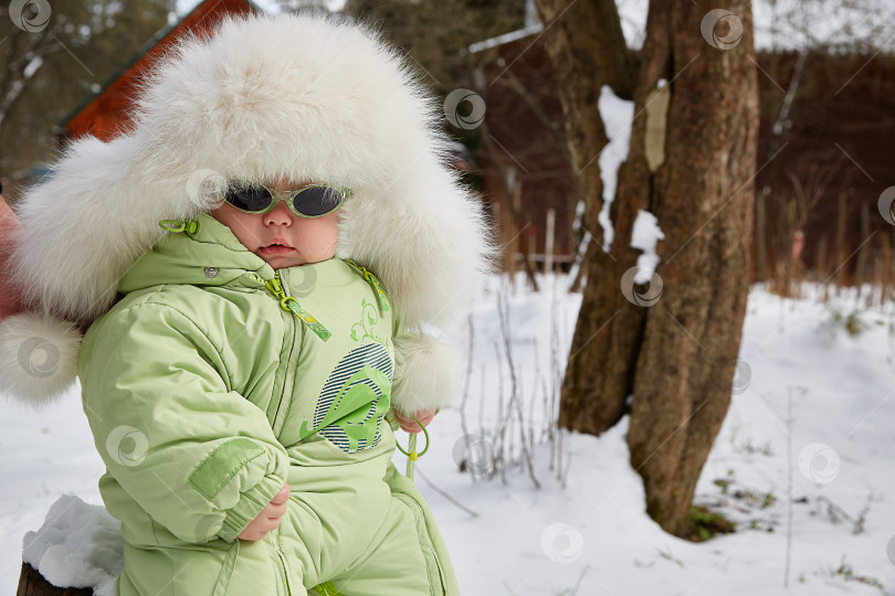 Скачать Ребенок в меховой шапке зимой. зимняя прогулка. фотосток Ozero