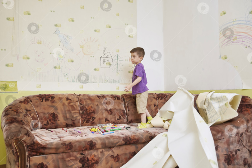 Скачать 5-летний ребенок срывает обои со стены дома во время карантина. образ жизни фотосток Ozero