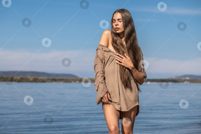 Скачать Портрет молодой брюнетки, позирующей в бежевой тунике фотосток Ozero