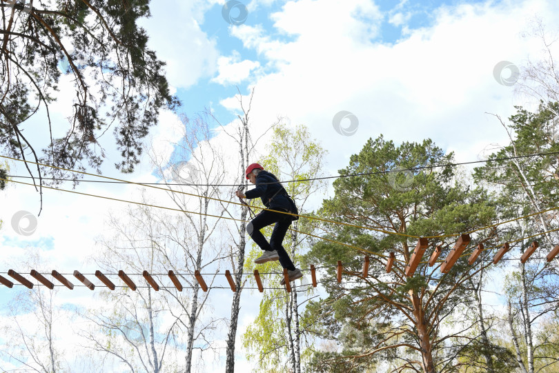 Скачать девочка-подросток преодолевает препятствие в веревочном парке фотосток Ozero