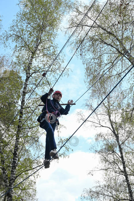 Скачать девочка-подросток преодолевает препятствие в веревочном парке фотосток Ozero