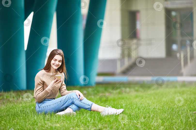 Скачать молодая девушка пишет смс. набирает текст на свой телефон. фотосток Ozero