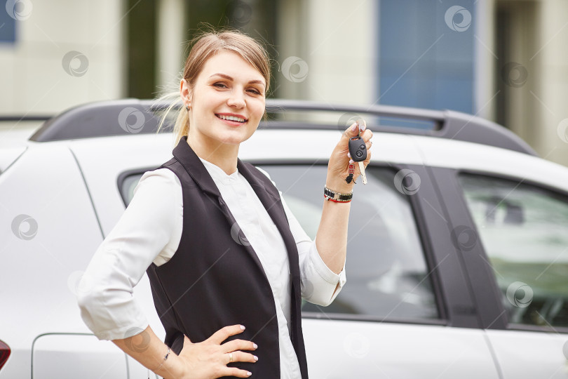 Скачать Женщина держит ключи от нового автомобиля auto и улыбается в камеру фотосток Ozero