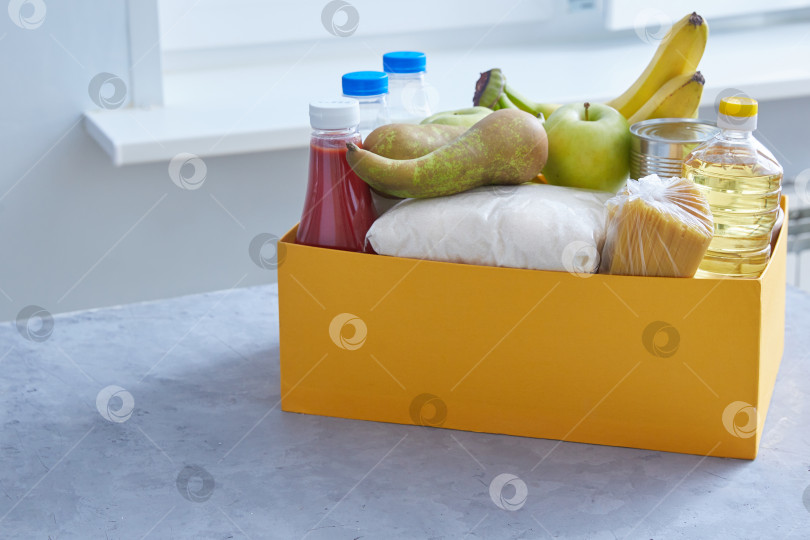 Скачать Набор продуктов для перекуса в желтой коробке. Выделите место на серо-голубом фоне. Пожертвование помогает бедным, безработным фотосток Ozero