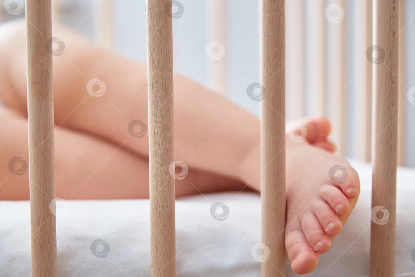Скачать Нога ребенка свисает с деревянной кровати. фотосток Ozero
