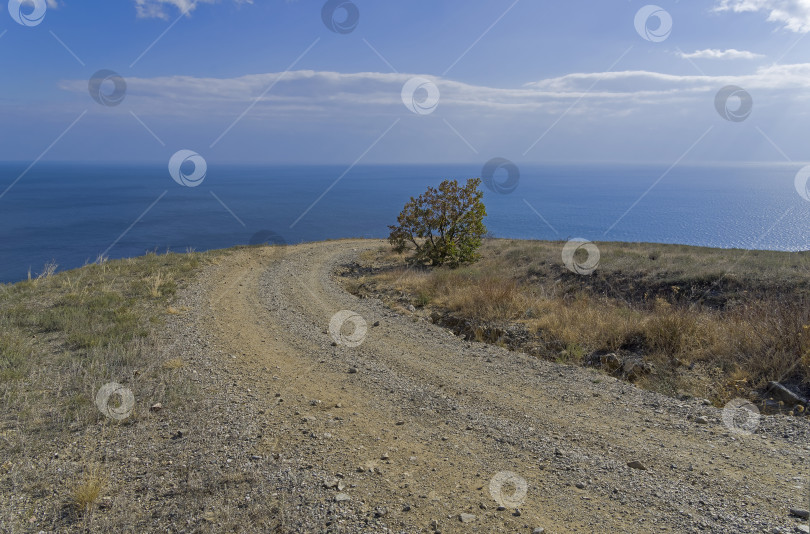 Скачать Крутой поворот на горную пыльную дорогу на берегу моря. фотосток Ozero