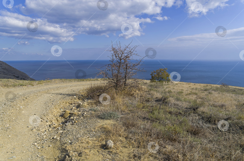 Скачать Крутой поворот на горную пыльную дорогу на берегу моря. фотосток Ozero