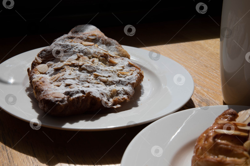Скачать миндальный круассан и булочка с кусочками клубники лежат на белой тарелке рядом с белой чашкой кофе капучино и латте еда свежая выпечка пекарня кухня ручной работы кафе завтрак здоровье фотосток Ozero