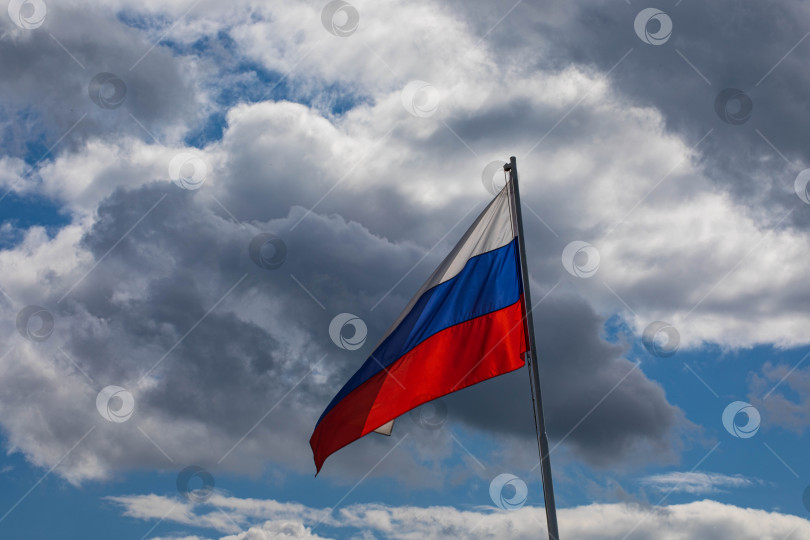 Скачать российский флаг развевается на ветру. российский трехцветный флаг-патриотизм, флаг мрачного неба на фоне неба фотосток Ozero