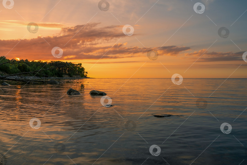 Скачать Чудесный оранжевый закат на скалистом берегу моря фотосток Ozero