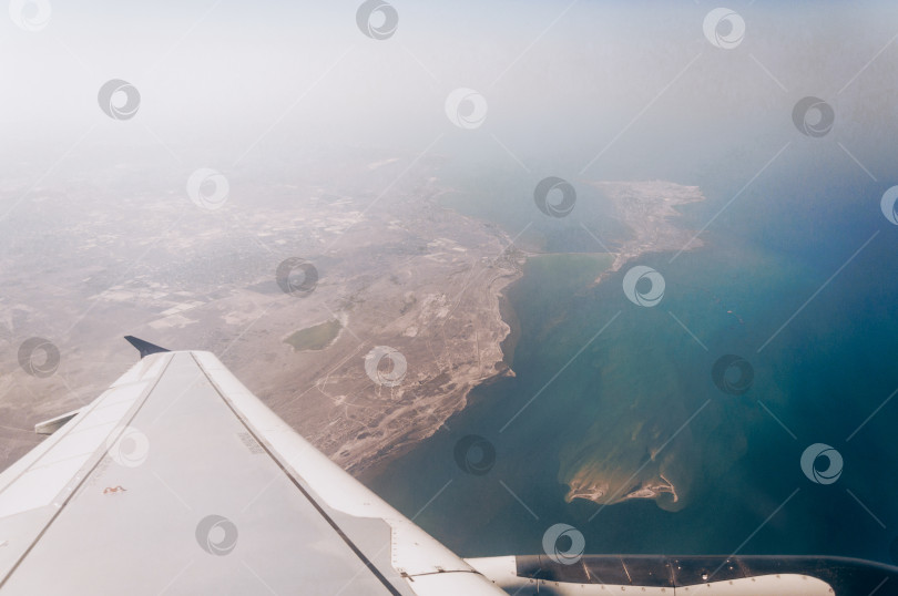Скачать Вид из иллюминатора самолета на крыло и землю сверху фотосток Ozero