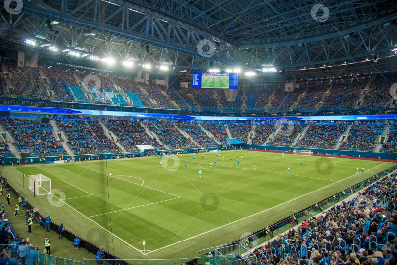 Скачать Санкт-Петербург, Россия, 30 октября 2019 года, Футбольный матч на футбольном поле, болельщики сидят на трибунах, футболисты бегут по зеленому газону фотосток Ozero