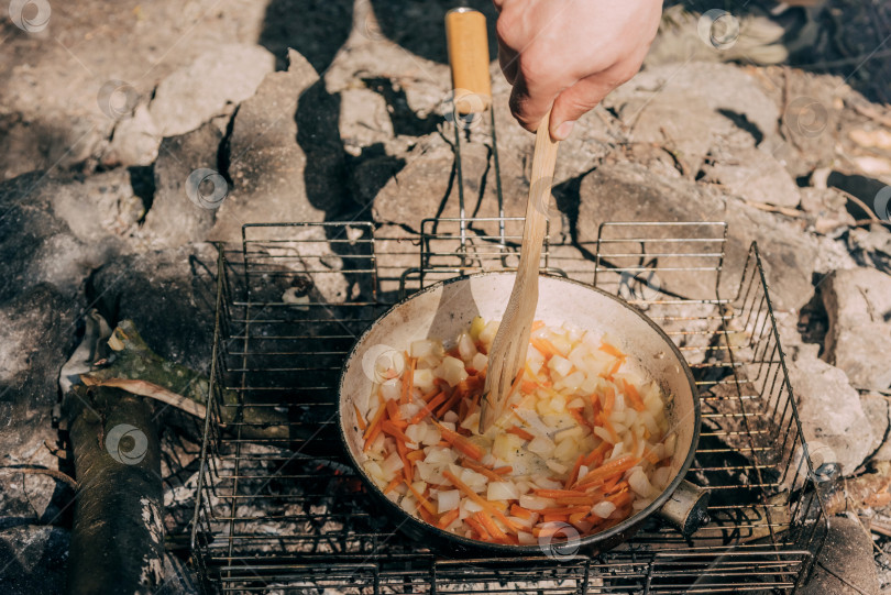 Скачать Походная кухня, Лагерь путешественников, готовящих еду в горшочках на костре фотосток Ozero