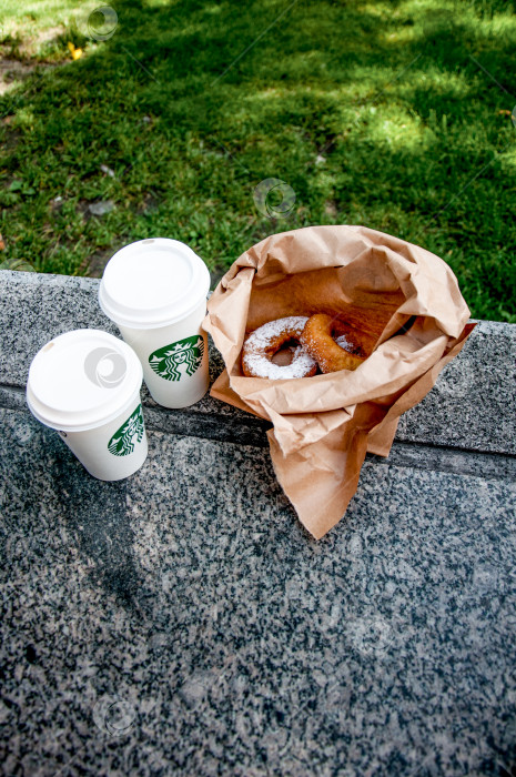 Скачать Санкт-Петербург, Россия, 7 августа 2015 года, кружка кофе Starbucks и пончик на столе фотосток Ozero