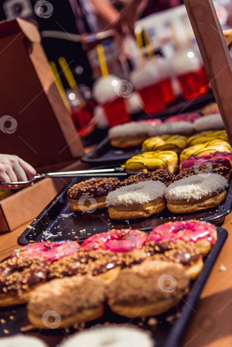 Скачать Пончики на прилавке магазина, десерты уличной кухни продаются в festival food фотосток Ozero