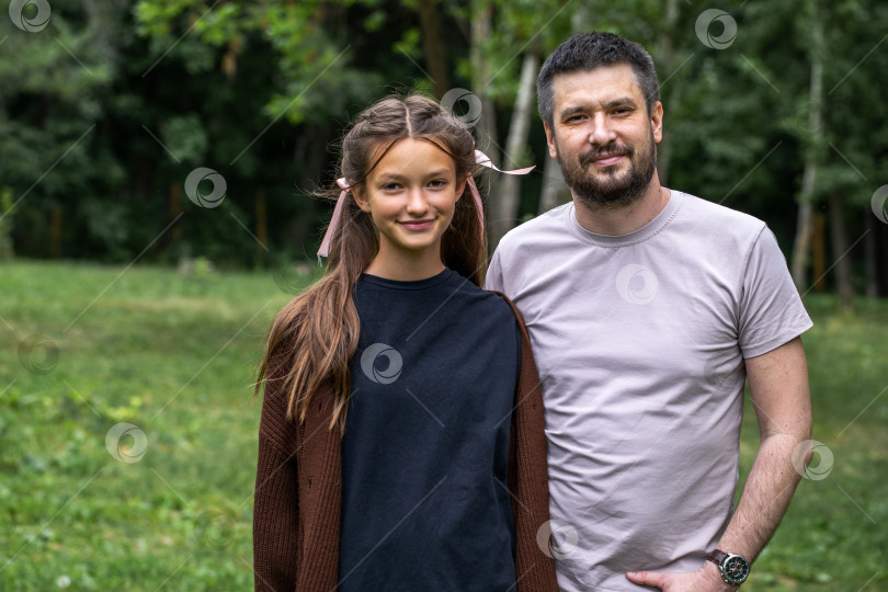 Скачать Отец средних лет и его дочь-подросток позируют в летнем парке фотосток Ozero