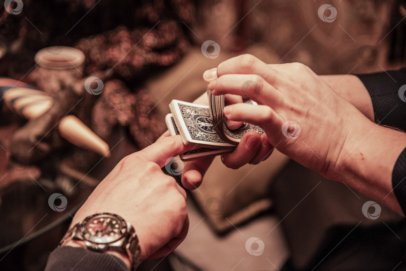 Скачать Санкт-Петербург, Россия, 12 марта 2018 года, Фокусник показывает карточный фокус, мужчина играет в азартные игры в казино, крупным планом руки, держащие колоду карт фотосток Ozero