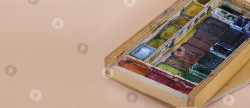 Скачать Старая деревянная шкатулка с акварельными красками, выделяющимися на простом фоне фотосток Ozero