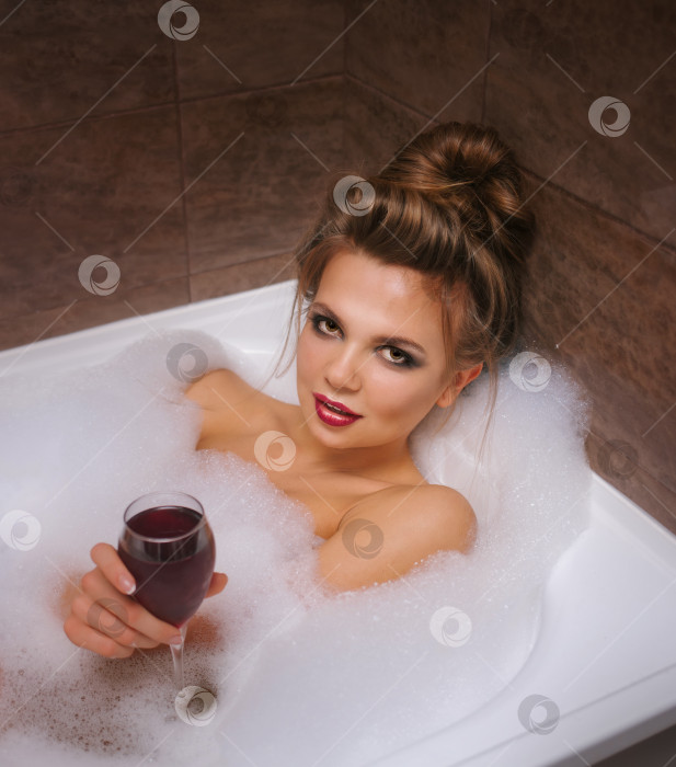Скачать Девушка пьет вино в ванне с пеной. фотосток Ozero