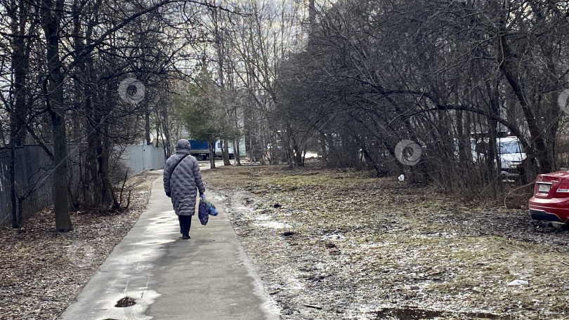 Скачать Женщина идёт по тротуару. Мытищи, Московская область, Россия, март 2025 г. фотосток Ozero