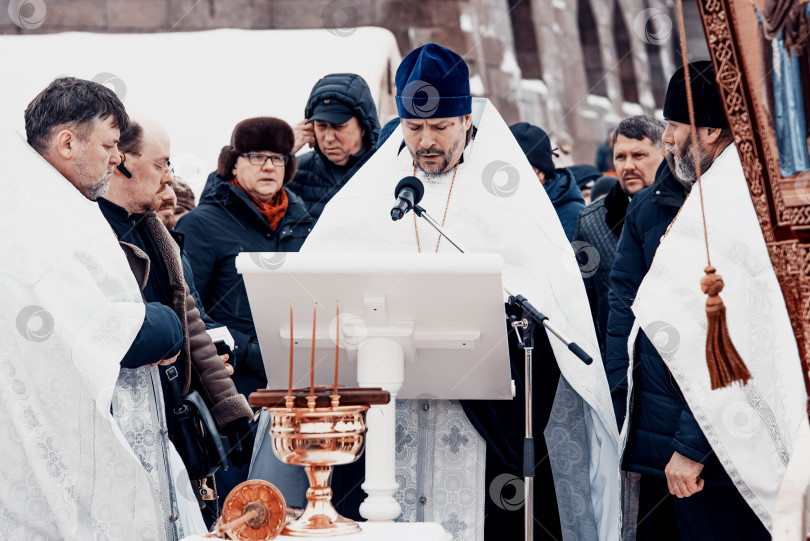 Скачать Санкт-Петербург, Россия, 19 января 2022 года, Священник освящает воду, держит крест фотосток Ozero