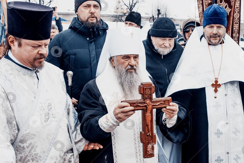 Скачать Санкт-Петербург, Россия, 19 января 2022 года, Священник освящает воду, держит крест фотосток Ozero
