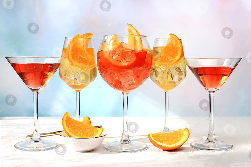 Скачать Праздничный алкогольный коктейль Aperol spritz, красный мартини, текила, ром, коктейли в бокалах и дольки апельсина на ярком фоне, концепция летнего бара, алкогольные напитки на вечеринке, реклама ресторанов и кафе,. фотосток Ozero