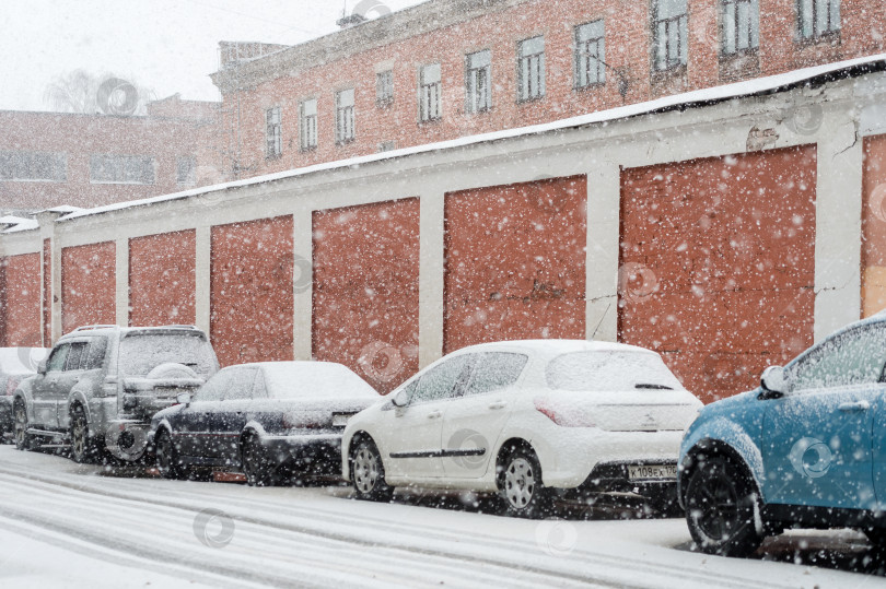 Скачать Россия, Санкт-Петербург, 3 марта 2025 года: Автомобили, припаркованные на обочине дороги в городе во время зимнего снегопада фотосток Ozero