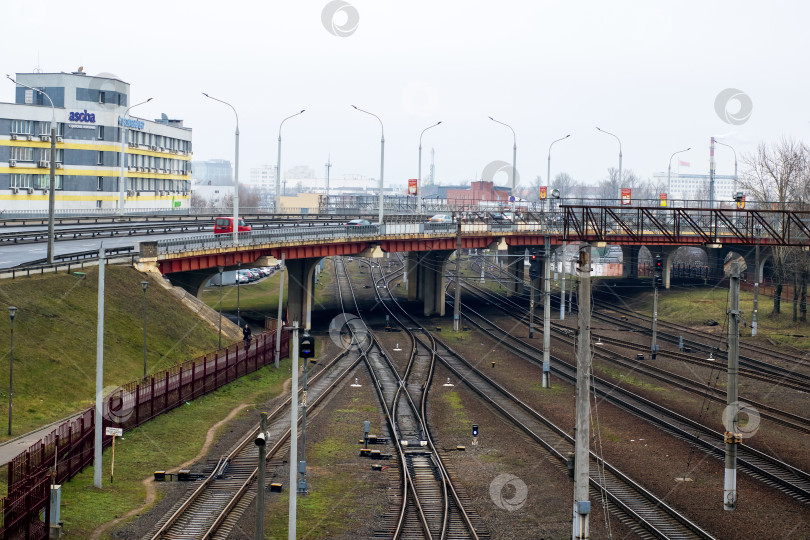 Скачать Беларусь, Минск - 02.01.2025: Мост через железнодорожные пути на фоне близлежащего здания фотосток Ozero