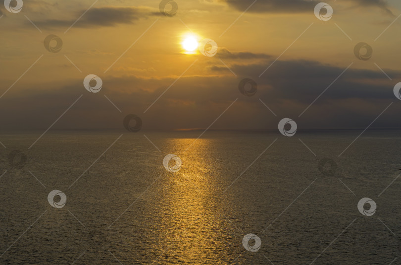 Скачать Солнце в облаках над морским горизонтом. фотосток Ozero