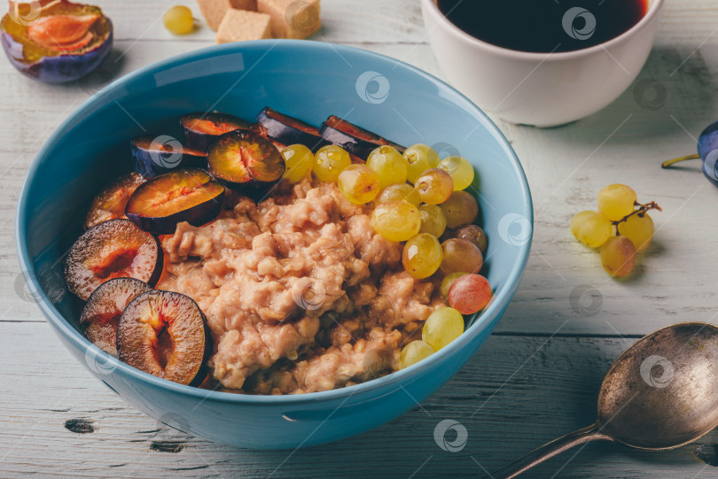 Скачать Овсяная каша со свежей сливой, зеленым виноградом и чашечкой кофе. фотосток Ozero