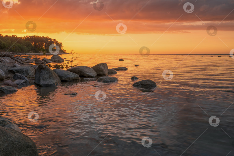 Скачать Чудесный оранжевый закат на скалистом берегу моря фотосток Ozero